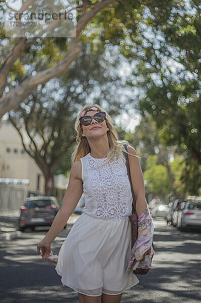 Junge Frau mit Sonnenbrille auf der Straße in der Stadt