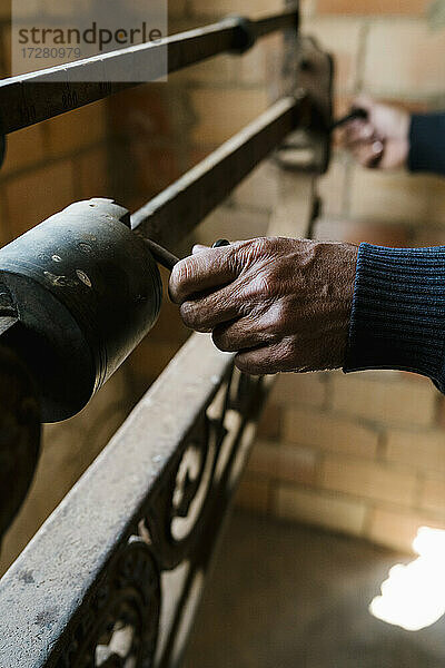 Hände eines Arbeiters beim Wiegen von Trauben auf einer altmodischen Waage in einer Weinkellerei