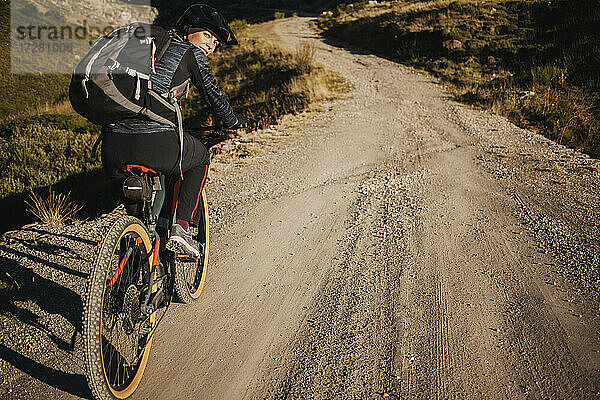 Mountainbikerin mit Rucksack auf dem Fahrrad auf einer Bergstraße im Naturpark Somiedo  Spanien