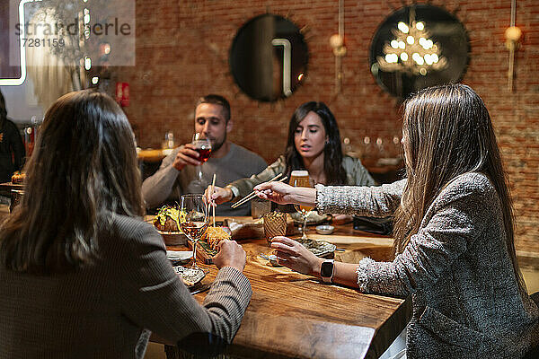 Freunde mit Getränken und Essen am Tisch im Restaurant