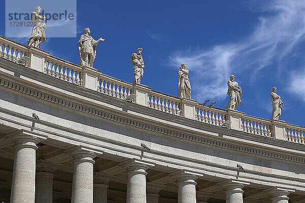 Heiligenstatuen auf dem Petersdom vor blauem Himmel an einem sonnigen Tag  Vatikanstadt  Rom  Italien