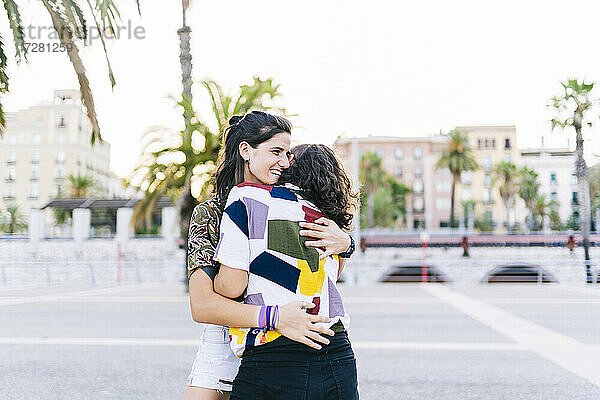 Glückliches lesbisches Paar umarmt sich auf der Straße