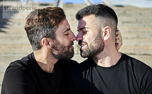 Romantisches homosexuelles Paar  das sich an einem sonnigen Tag im Freien küsst