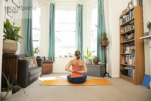 Ältere Frau macht pashchima namaskarasana Position beim Sitzen auf dem Boden