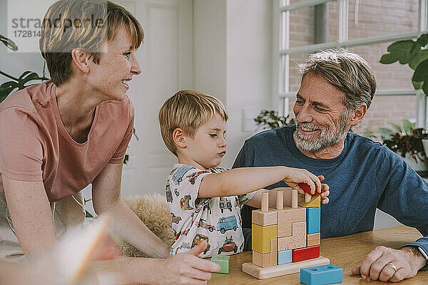Mutter und Vater spielen mit Sohn Spielzeug Block Puzzle zu Hause