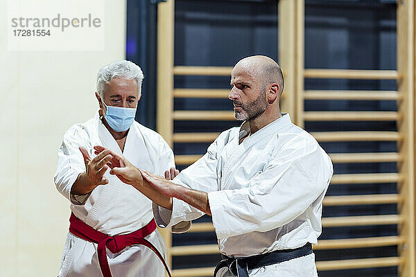 Ausbilder unterrichtet einen männlichen Schüler in Karate