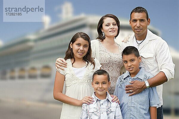 Junge glückliche hispanische Familie auf dem Steg vor einem Kreuzfahrtschiff