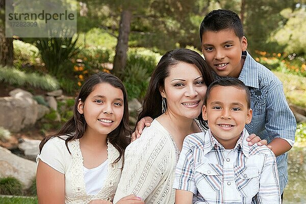 Glückliche hispanische Mutter und Kinder im Park