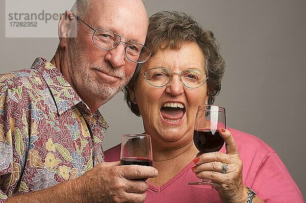 Glückliches älteres Paar stößt mit Weingläsern an