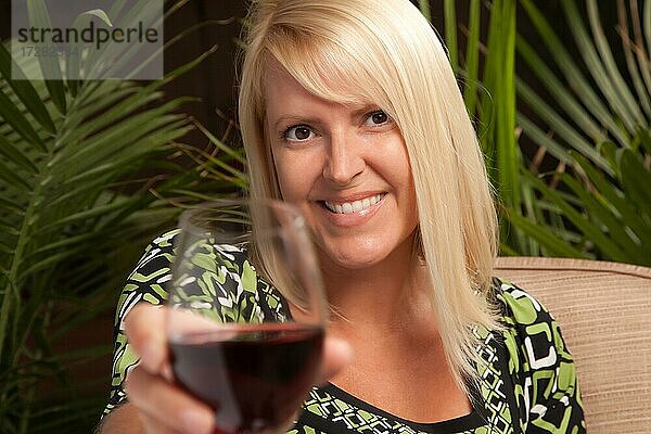Schöne blonde lächelnde Frau bei einem Abend geselliges Beisammensein Verkostung Wein
