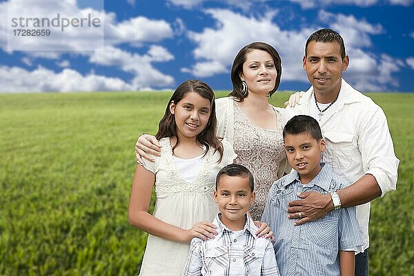 Glückliche hispanische Familie Porträt stehen in Wiese