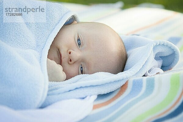 Schöne kleine Baby Junge ruht in seiner warmen Decke
