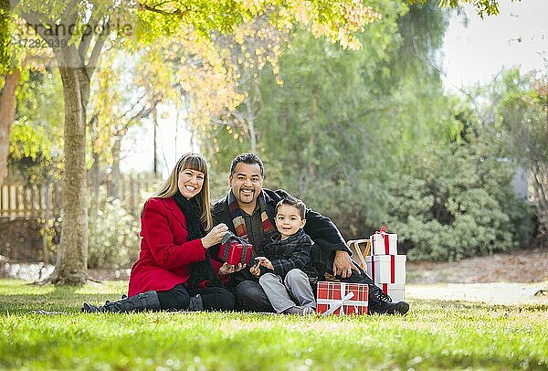 Junge gemischtrassige Familie genießt Weihnachtsgeschenke im Park zusammen