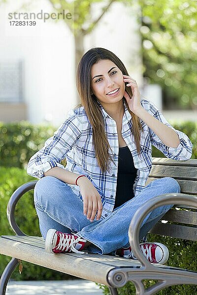 Glückliche gemischtrassige Studentin Porträt auf Schulcampus Bank