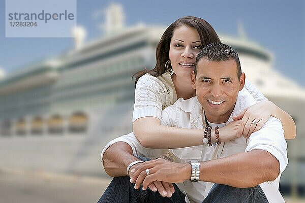Junge glückliche hispanische Paar umarmt auf dem Dock vor einem Kreuzfahrtschiff