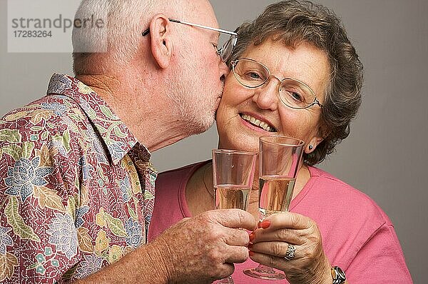 Glückliches Seniorenpaar stößt mit Sektgläsern an