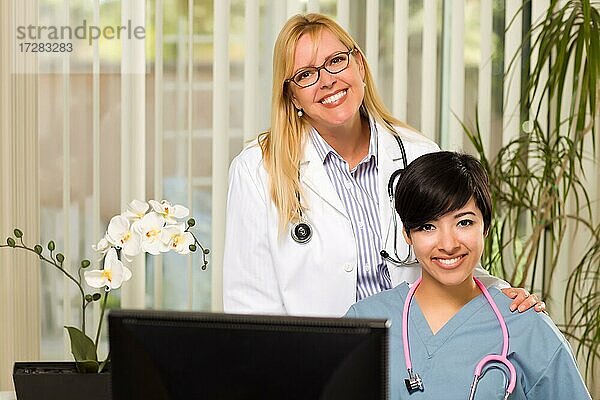 Lächelnde gemischtrassige Ärztinnen oder Krankenschwestern  die in einer Büroumgebung zusammenarbeiten