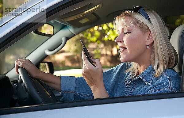 Attraktive blonde Frau Text-Messaging auf ihrem Handy während der Fahrt