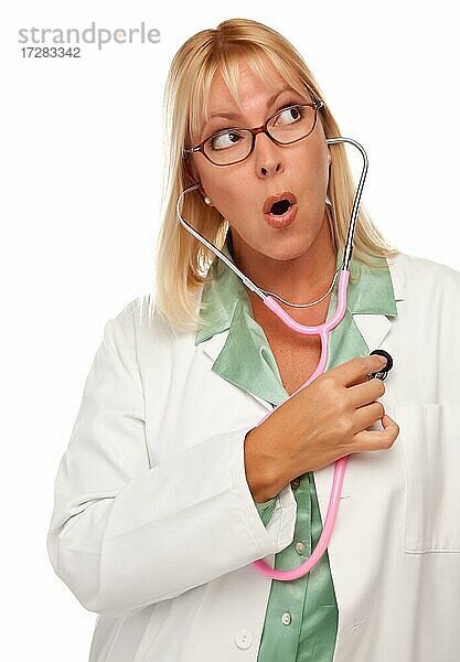 Attraktive Ärztin oder Krankenschwester überprüft ihr eigenes Herz vor einem weißen Hintergrund
