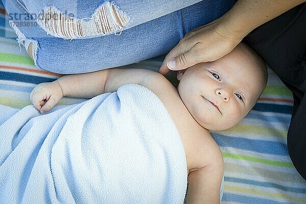 Schöne kleine Baby-Junge eingewickelt in seine Decke ruht mit Mama