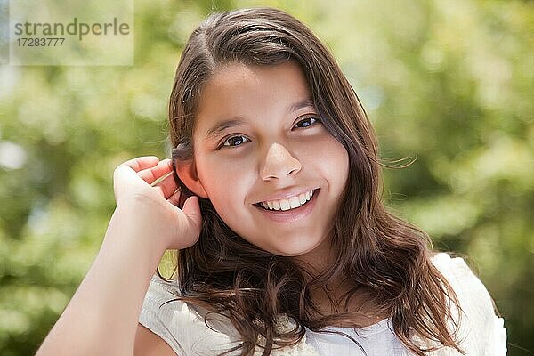 Nette glückliche hispanische Mädchen Porträt im Park