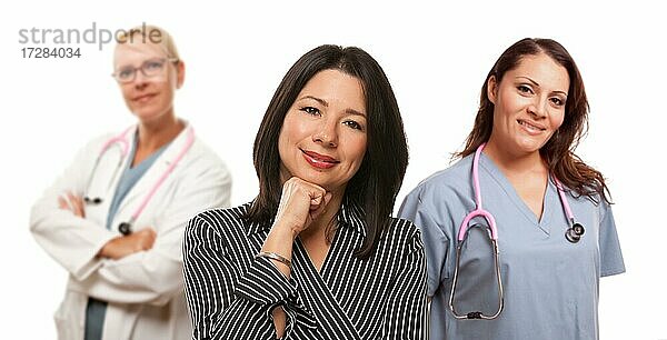 Hispanic Frau mit Ärztin und Krankenschwester vor einem weißen Hintergrund