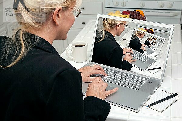 Frau in Küche mit Laptop. Bildschirm kann leicht für Ihre eigene Nachricht oder Bild verwendet werden. Bild auf dem Bildschirm ist auch mein Copyright