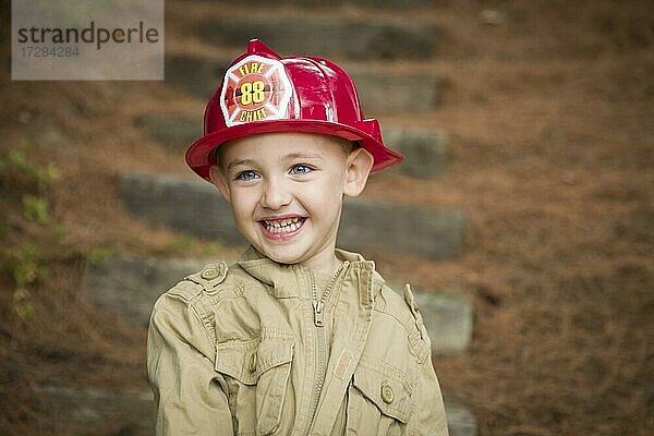 Glücklich adorable Kind Junge mit Feuerwehrmann Hut draußen spielen
