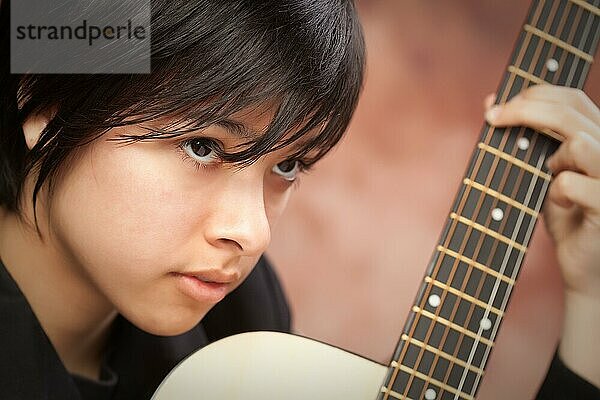 Attraktives ethnisches Mädchen genießt es  ihre Gitarre zu spielen
