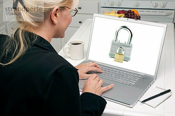 Frau in der Küche mit Laptop mit hoher Sicherheitsstufe. Bildschirm kann leicht für Ihre eigene Nachricht oder Bild verwendet werden