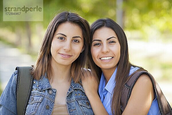 Junge erwachsene gemischtrassige Zwillingsschwestern Porträt tragen Rucksäcke außerhalb