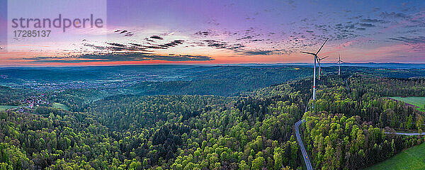 Deutschland  Baden Württemberg  Luftaufnahme des Schwäbischen Waldes mit Windkraftanlagen entlang der Straße bei Sonnenaufgang