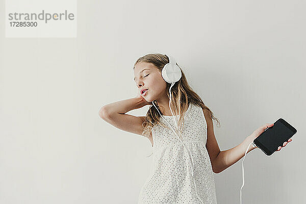 Mädchen mit geschlossenen Augen wiegt sich auf Musik