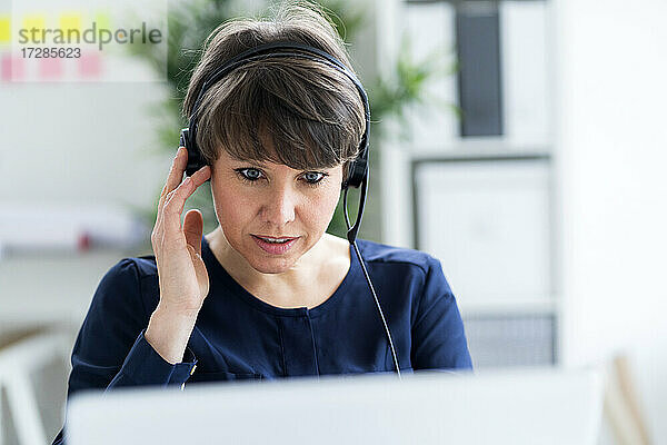 Geschäftsfrau mit Headset bei der Arbeit im Büro
