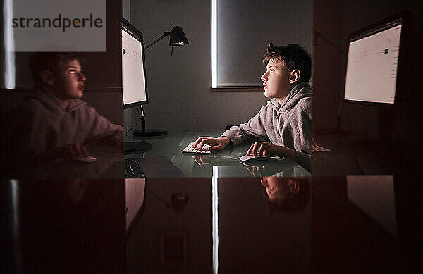 Seriöser Junge benutzt Computer zu Hause