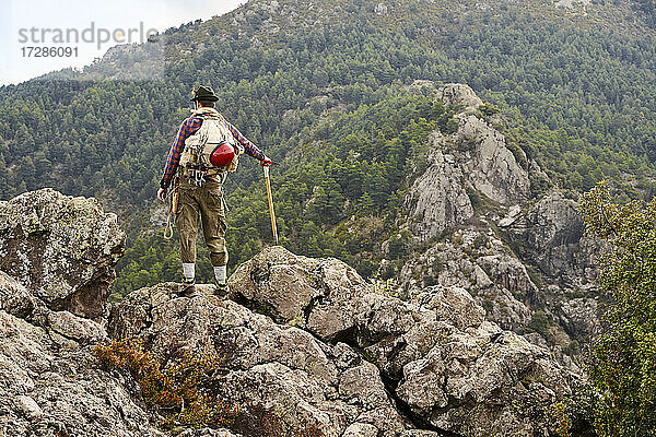 Mittlerer erwachsener männlicher Bergsteiger  der auf einem Berg stehend die Aussicht betrachtet