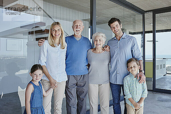 Glückliche Mehrgenerationenfamilie vor einer Glaswand
