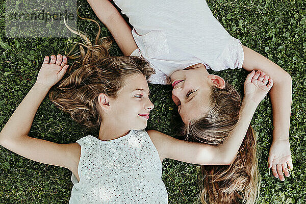 Lächelnde Mädchen  die sich im Sommer im Gras entspannen