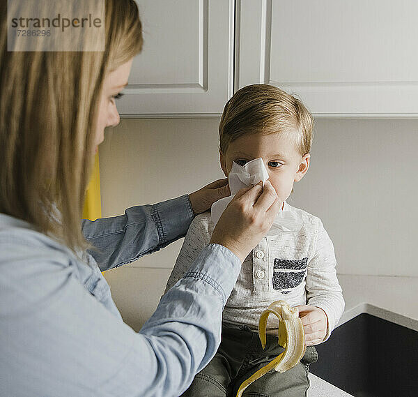 Mutter putzt die Nase des Sohnes zu Hause
