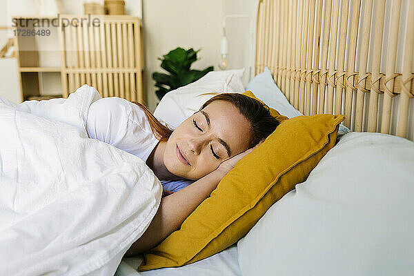Schöne Frau mit geschlossenen Augen schlafend im Bett zu Hause