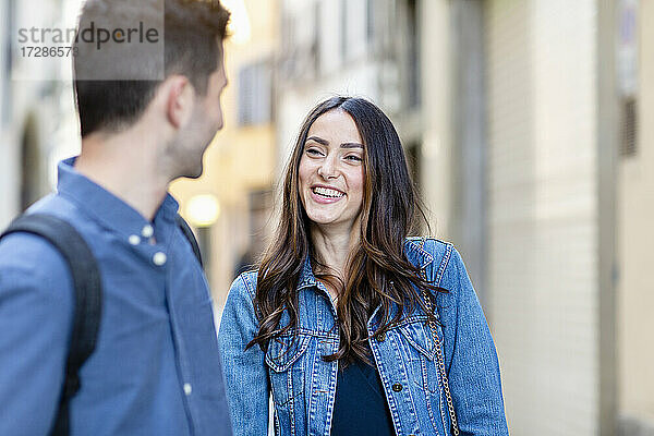 Junge Frau lächelt  während sie einen Mann ansieht