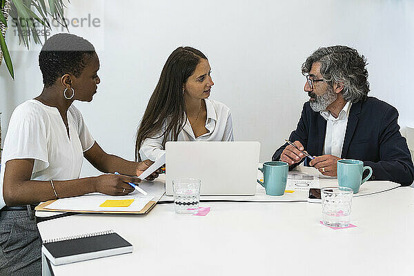 Männliche und weibliche Fachleute diskutieren während einer Besprechung im Büro