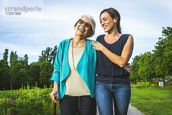 Glückliche Frauen gehen zusammen im Park spazieren