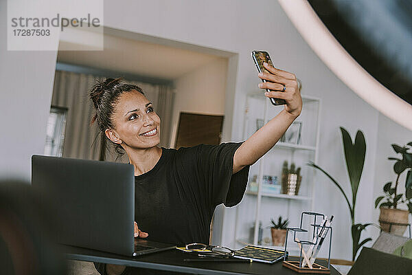 Geschäftsfrau nimmt Selfie durch Smartphone im Büro