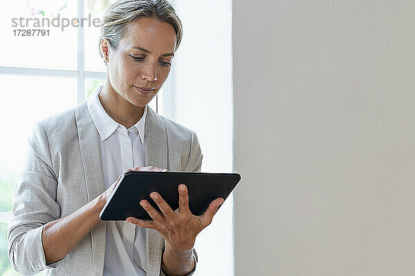 Unternehmerin nutzt digitales Tablet im Büro