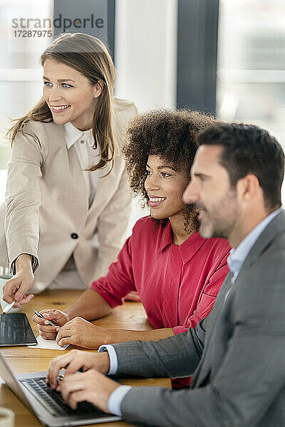 Lächelnde männliche und weibliche Unternehmer  die ins Büro schauen