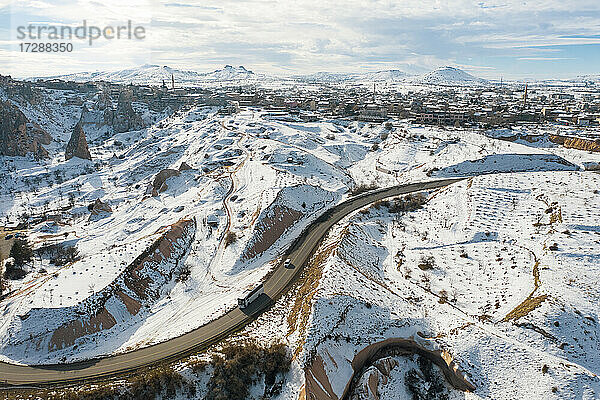 Luftaufnahme einer Autobahn  die sich durch schneebedecktes Gelände in Kappadokien zieht