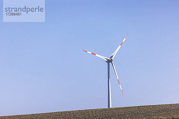 Windturbine vor strahlend blauem Himmel