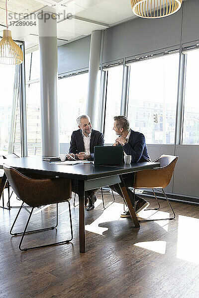 Geschäftsleute besprechen einen Geschäftsplan  während sie am Schreibtisch im Büro sitzen
