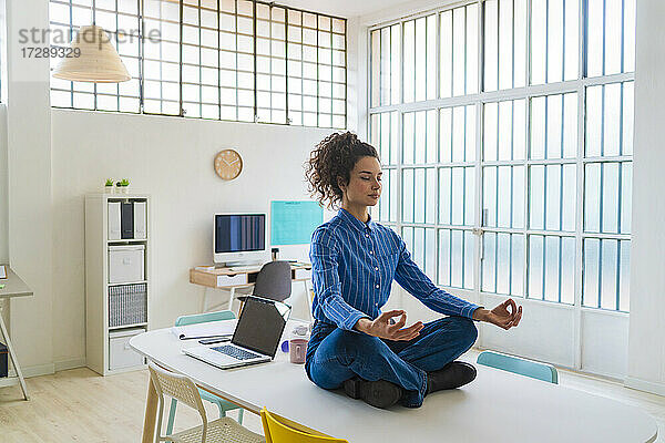 Unternehmerin beim Meditieren im Büro sitzend